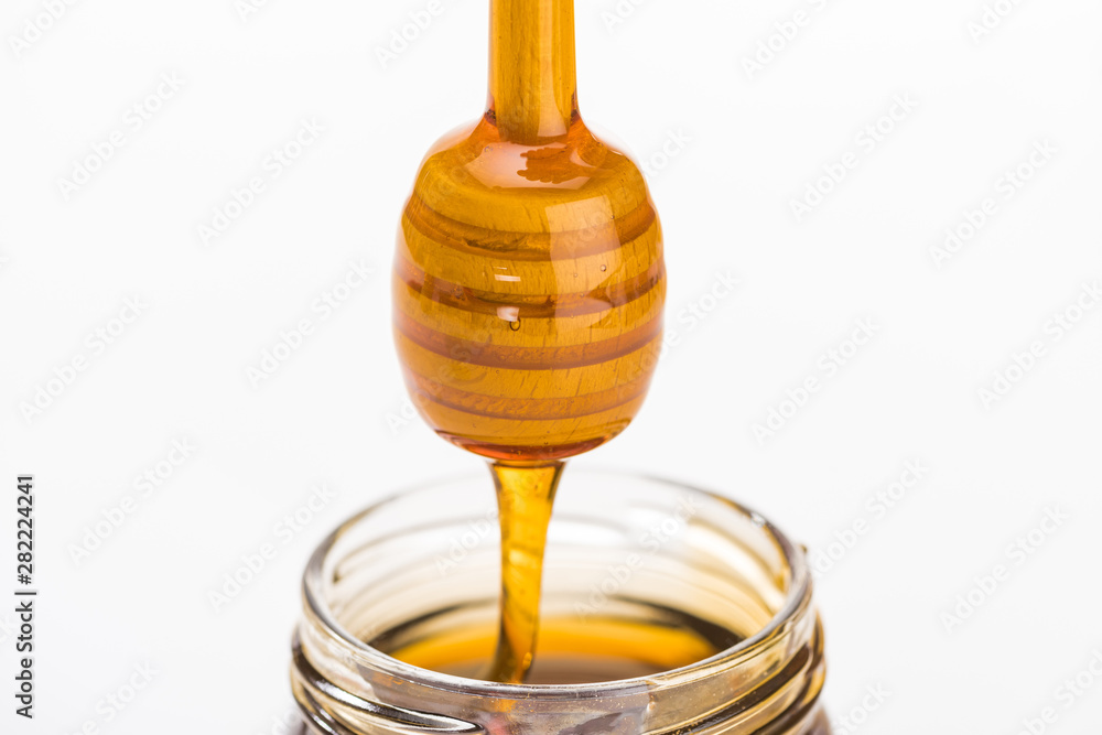 wooden honey dipper with dripping honey isolated on white wooden honey dipper with dripping honey isolated on white
