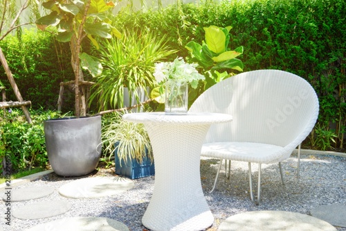 White wicker chair and white wicker table in the garden with light at morning.Relax concepts.