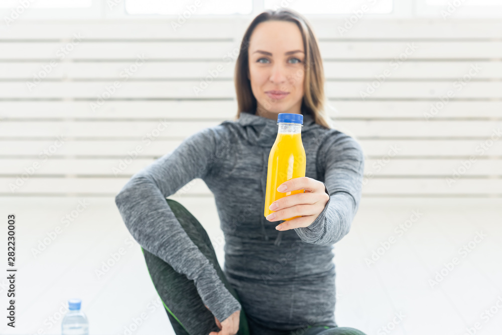 Healthy lifestyle, sport and people concept - beautiful young girl with a fitness smoothie and bottle of water Healthy lifestyle, sport and people concept - beautiful young girl with a fitness smoothie and bottle of water