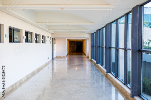 long empty corridor with large glass windows. Modern corridor. Commercial architecture © Denis