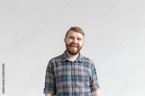 Handsome young man smiling and laughing on white background with copy space