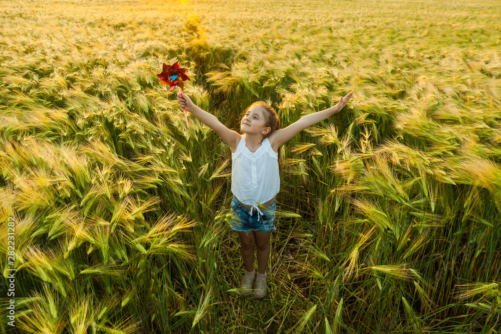 Little girl playing on the meadow in wheat field. Little girl playing on the meadow in wheat field.