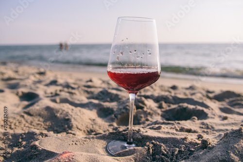 glass of red wine at sunset on the sea coast