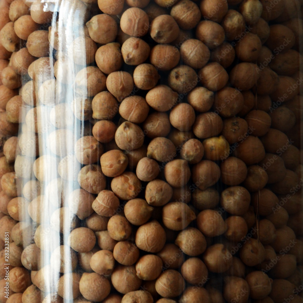 Dried chickpeas in glass jar on gray background Dried chickpeas in glass jar on gray background