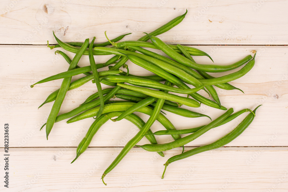 Lot of whole fresh green bean flatlay on white wood Lot of whole fresh green bean flatlay on white wood
