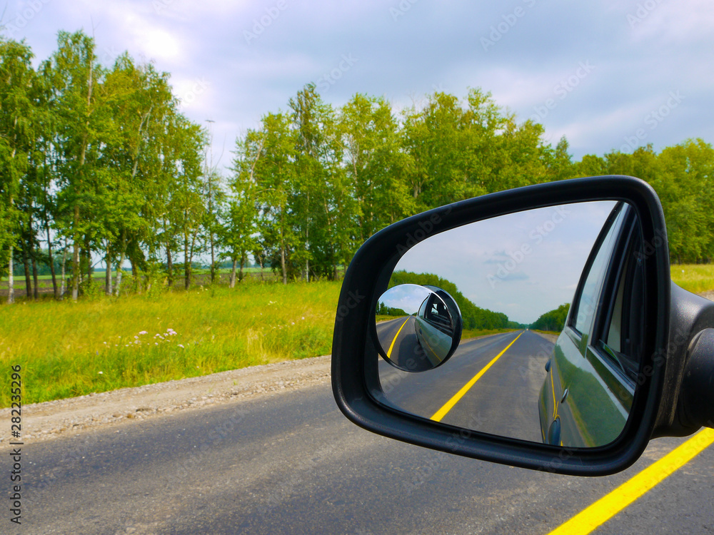 The insured car is a guarantee of safety. Traveling by car with the whole family. View through the car window to the rearview mirror.