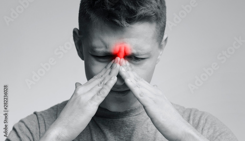 Frustrated young man suffering from sinus pressure photo