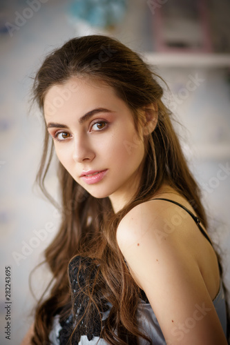 Portrait of beautiful young woman standing at vintage kitchen in pajama set