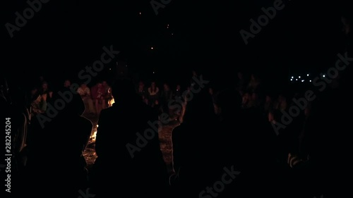 Many people are sitting near the campfire. Bonfire camping silence calm summer holidays warm.
