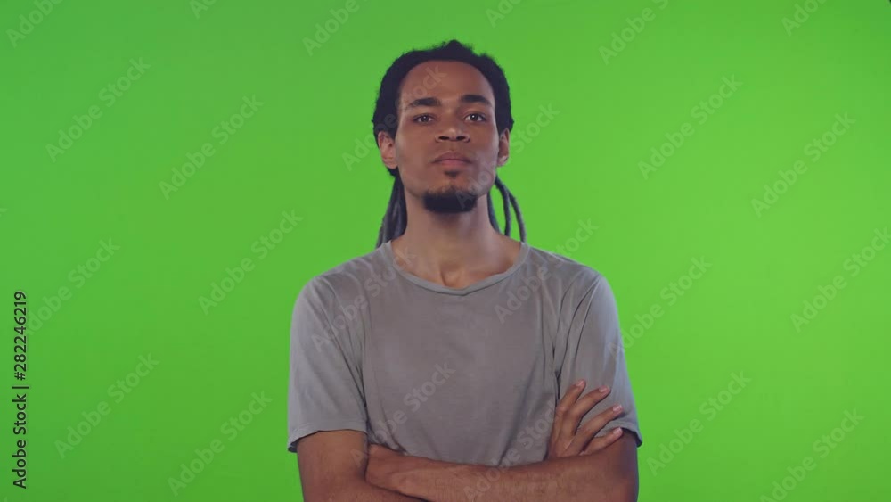 Portrait of an african american young guy with long dreadlocks saying no on green screen background. Concept of a man denying violation of rights and freedoms. Chroma key Portrait of an african american young guy with long dreadlocks saying no on green screen background. Concept of a man denying violation of rights and freedoms. Chroma key