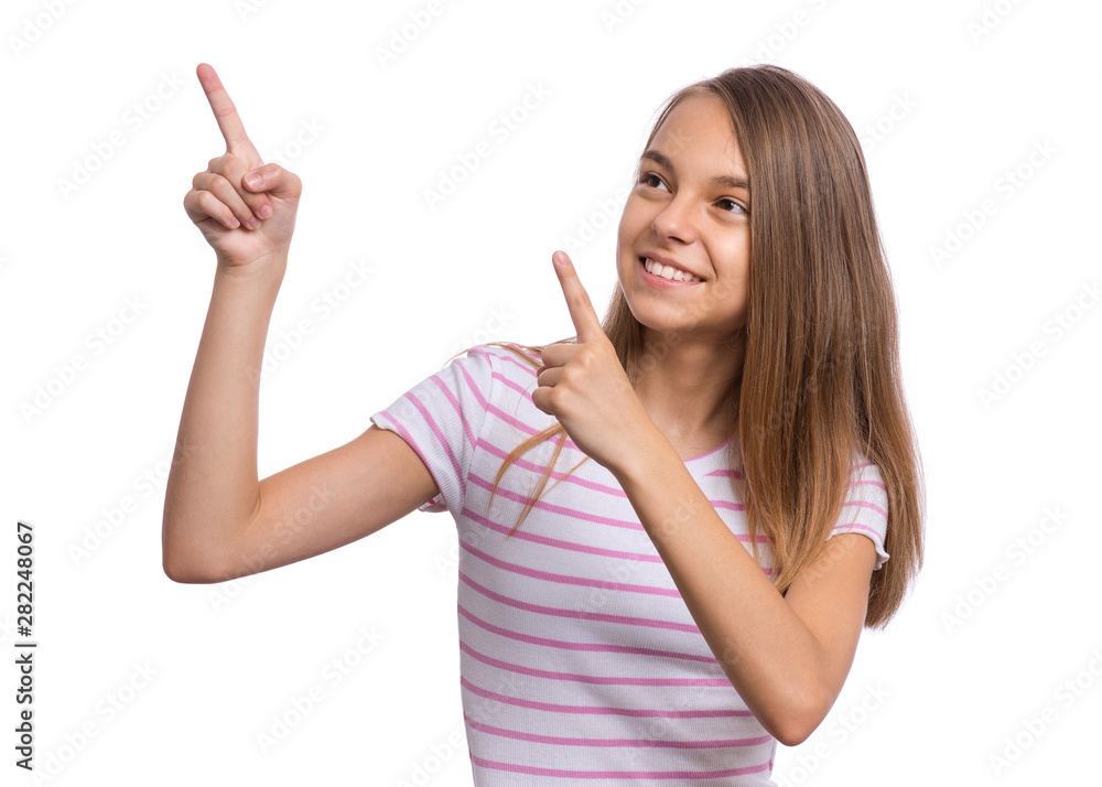 Portrait of teen girl pointing finger away at copyspace, isolated on white background. Beautiful caucasian young teenager smiling and attracted by attention pointing finger at something. Happy child. Portrait of teen girl pointing finger away at copyspace, isolated on white background. Beautiful caucasian young teenager smiling and attracted by attention pointing finger at something. Happy child.