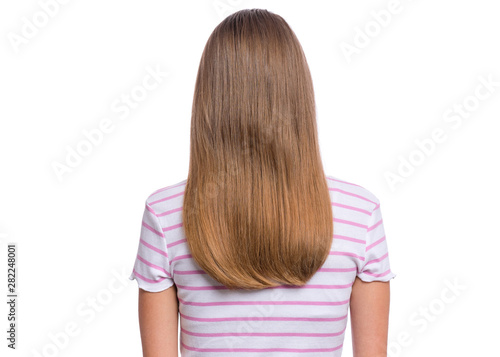 Rear view of teen girl with long hair, isolated on white background. Portrait of caucasian child - back view.