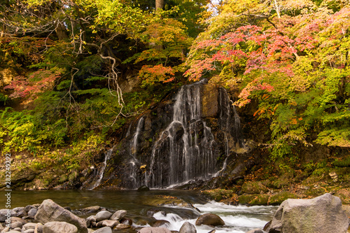 Autumn leaves and waterfall at Nakano Momiji mountain, Kuroishi, Aomori, Japan photo