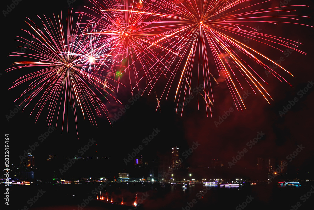 Vibrant red fireworks splashing in the city's night sky Vibrant red fireworks splashing in the city's night sky