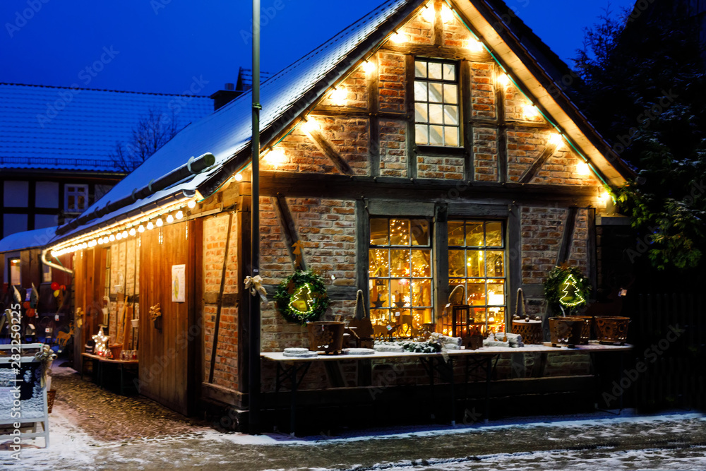 Fototapeta premium Decorated house on Christmas in Germany covered with snow. Festive lights, garlands. Beautiful holiday season