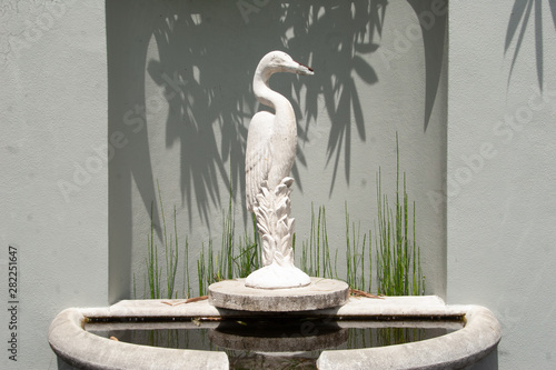 Crane fountain with leaf shadows