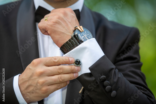 Wedding details, cufflinks, elegant male suit and hands