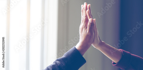 Businessmen, men and two women put together shaking hands to show the victory in the work they performed to show the victory in the work they performed, for panoramic banner background with copy space