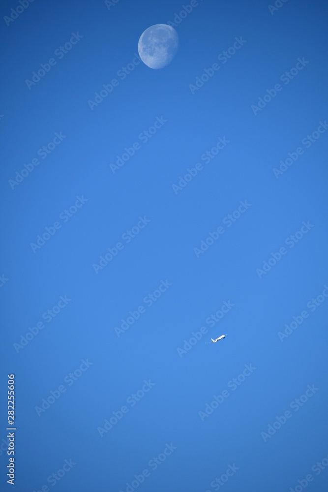 Aeroplane and the moon in a blue sky background Aeroplane and the moon in a blue sky background