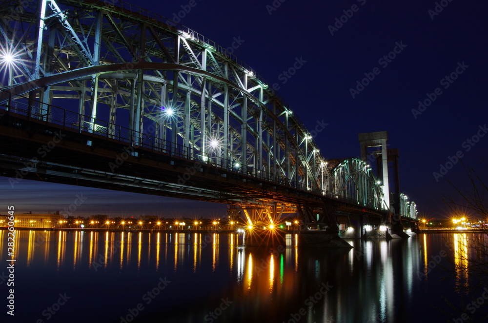 Finland Railway Bridge over Neva river, Saint-Petersburg, summer night, calm water surface, Russia