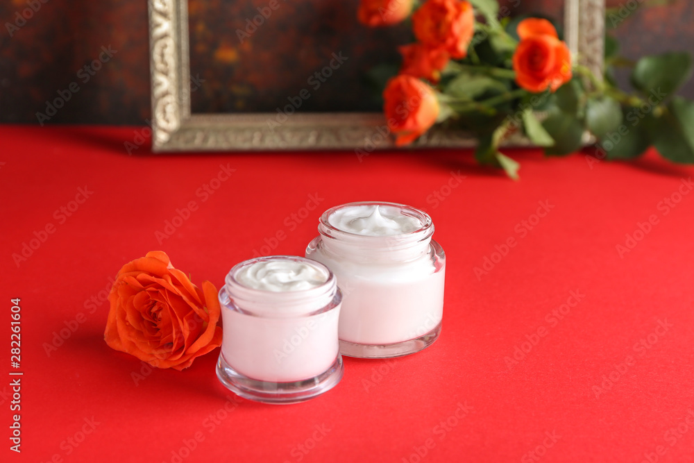 Body cream with rose flower on color table Body cream with rose flower on color table