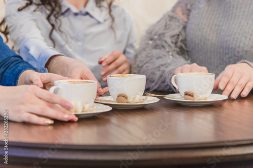 Female friends having a coffee together. Three women at cafe drinking, talking, laughing and enjoying their time. Lifestyle and friendship concepts with real people models.