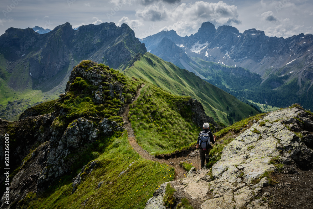 Un escursionista solitario percorre un sentiero in cresta in alta quota sulle Dolomiti