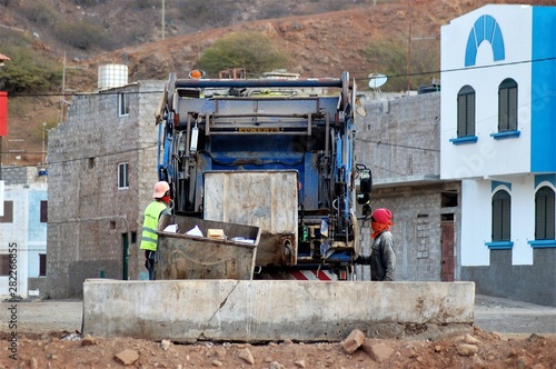  Waste collectors emptying rubbish on the truck