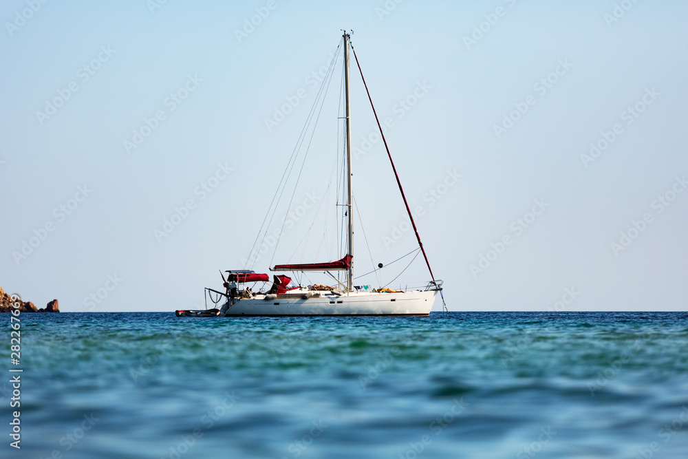 White sailing boat against sea horizon.