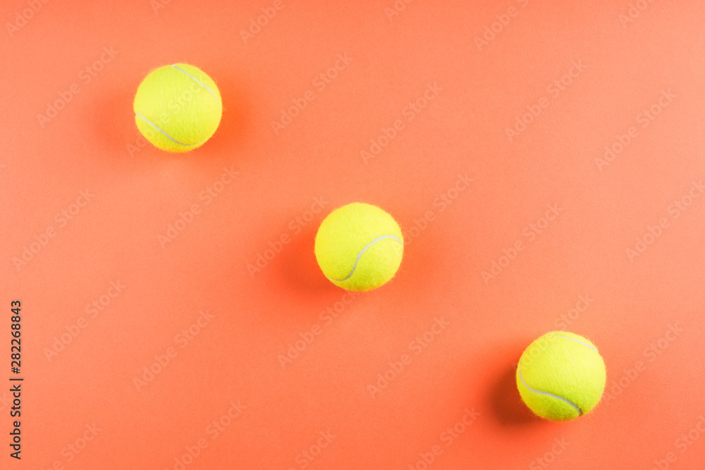 Three tennis balls on orange. Concept