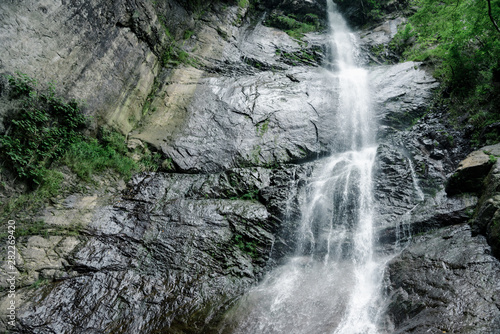 The highest and most impressive waterfall of Georgia is Mahunceti  about 30 meters high  surrounded by trees  a mountain of dark  almost black color.