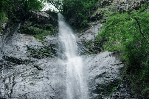 The highest and most impressive waterfall of Georgia is Mahunceti  about 30 meters high  surrounded by trees  a mountain of dark  almost black color.