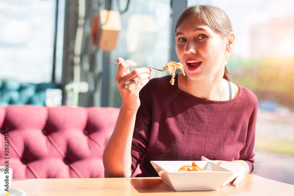 Girl eating chicken nuggets with salad in a restaurant Girl eating chicken nuggets with salad in a restaurant