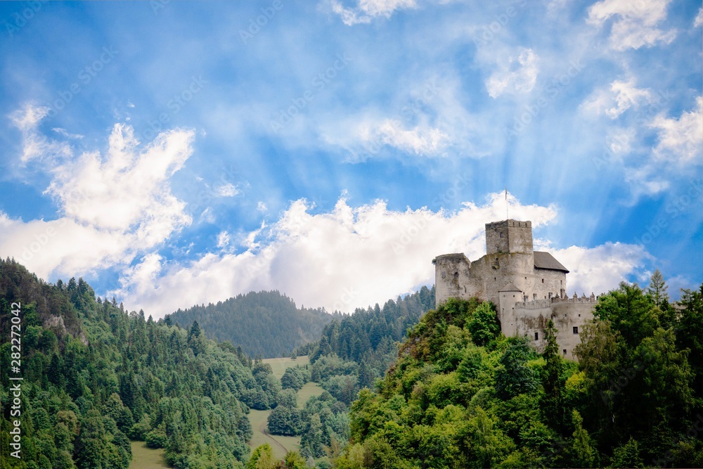 Medieval castle on the green hill and sky with sun rays. Beautiful nature. Niedzica, Poland