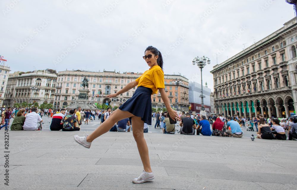 ragazza giovane sorridente in giallo presso piazza Duomo milano
