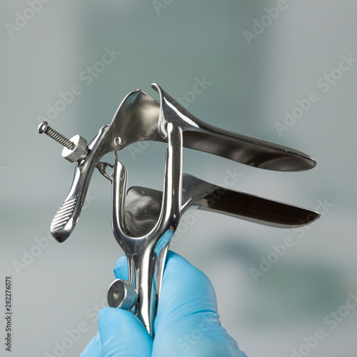 doctor's hand holds a medical speculum
