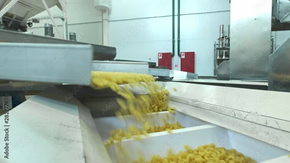 Pasta factory and pasta production stages. Close up of dry macaroni
