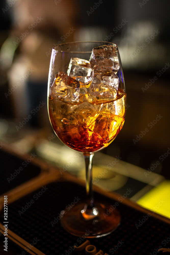Close-up orange cocktail on the bar, dark blurred background. Close-up orange cocktail on the bar, dark blurred background.