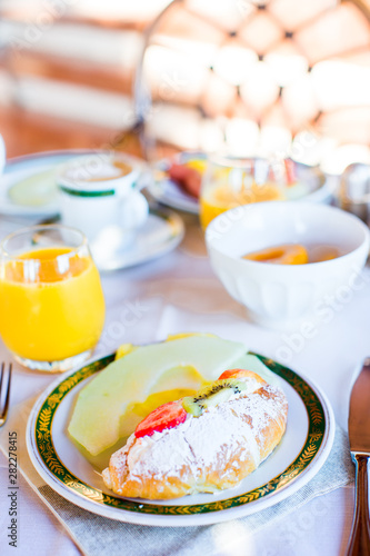 Healthy breakfast with fresh juice and sweet croissant in restaraunt resort outdoor