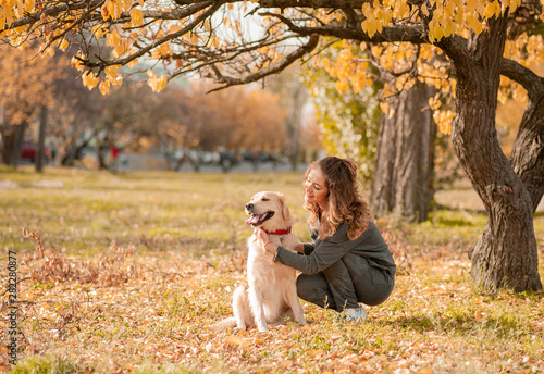 Beautiful smiling woman with cute golden retriever dog © trofalena