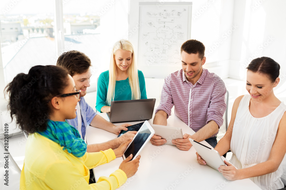 business, technology and startup concept - happy creative team with table pc computer at office business, technology and startup concept - happy creative team with table pc computer at office