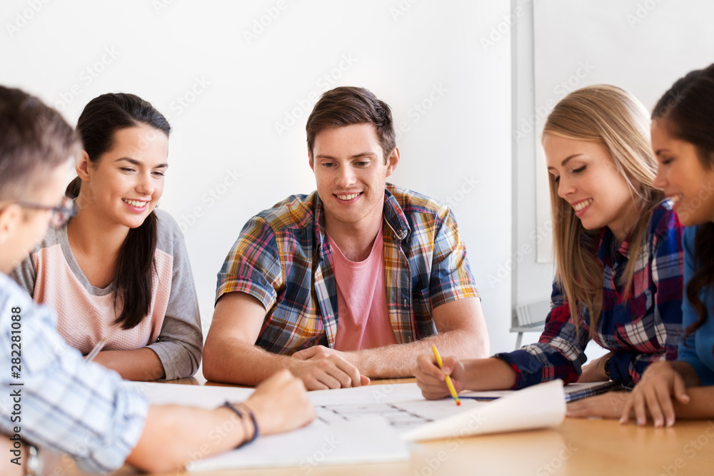 education, architecture and people concept - group of smiling students with blueprint meeting indoors education, architecture and people concept - group of smiling students with blueprint meeting indoors