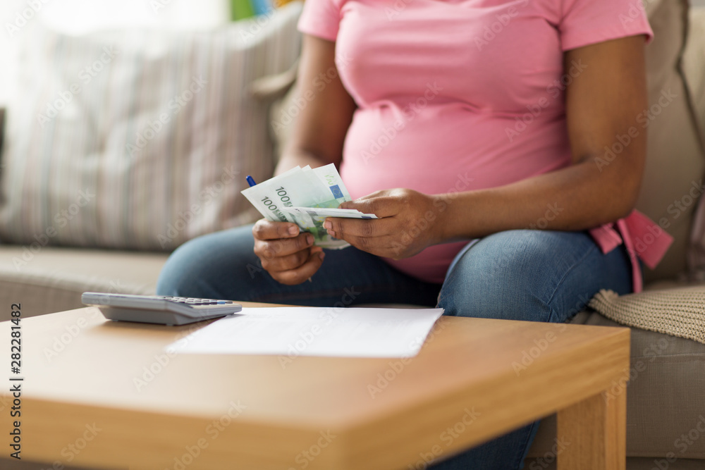 Fototapeta oszczędności, finanse i ludzie pojęć, - zamyka up ciężarna amerykanin afrykańskiego pochodzenia kobieta z papierami i kalkulatorem odliczającym pieniądze w domu