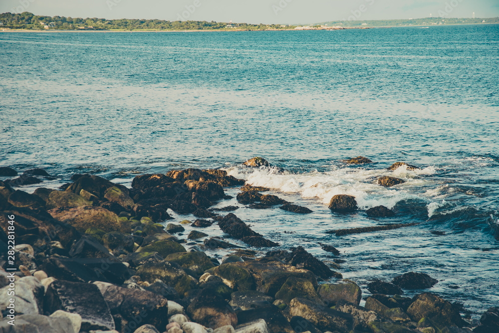 Obraz premium Rhode Island ocean rocks at sunset
