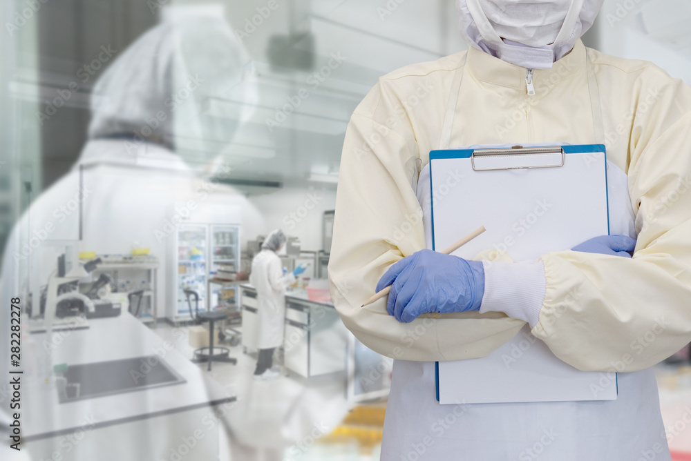 Lab worker in Protective Clothes and mask with gloves for doing research in foods factory or pharmaceutical. Double Exposure image with Laboratory Scientists Background.