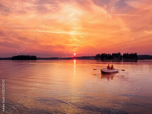 Romantic vibrant sunset river lake fog loving couple small rowing boat date beautiful Lovers ride during Happy woman man together relaxing water nature around