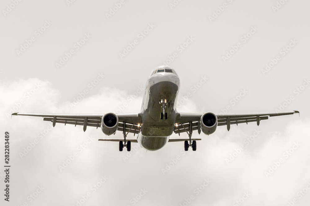 Airbus a320 landing landing in cloudy sky.