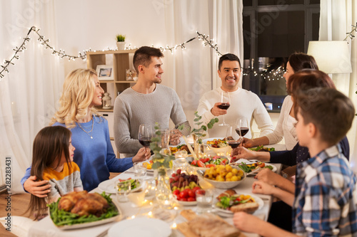 celebration  holidays and people concept - happy family having dinner party  drinking red wine and toasting at home