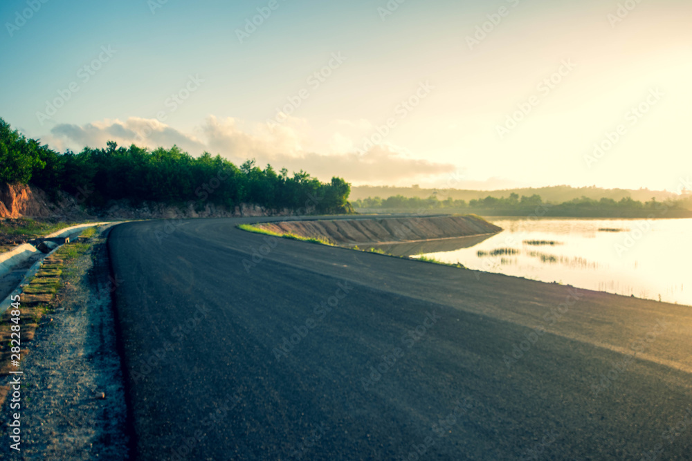 Fototapeta premium view of road way along side with reservoir at Nathongsuk reservoir, Songkhla, Thailand. (Selective focus)