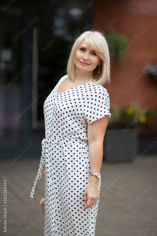 Portret happy Elegant middle aged woman  walks down the street in summer day. positive. positive. happy lifestyle concept